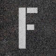 Stencil alphabet letters paint on asphalt road 
