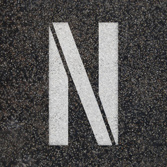 Stencil alphabet letters paint on asphalt road 