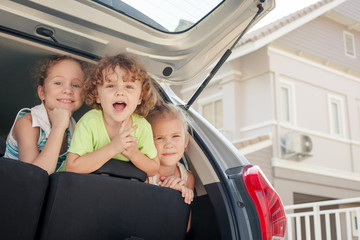 three happy kids in the car