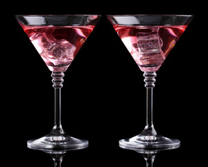 Red cocktail in martini glasses isolated on black