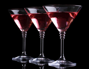 Red cocktail in martini glasses isolated on black