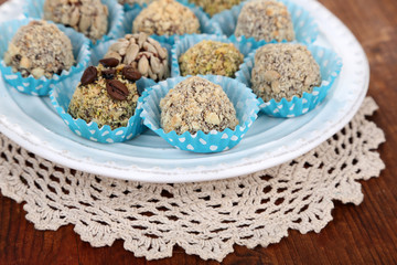 Set of chocolate candies, on plate, on wooden background