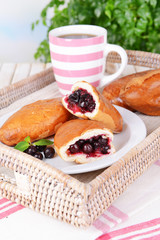 Fresh baked pasties with currant on plate on table close-up
