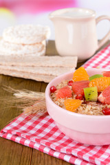 Delicious oatmeal with fruit in bowl on table close-up