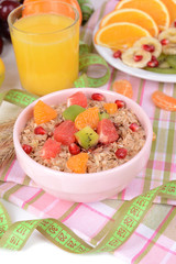 Delicious oatmeal with fruit in bowl on table close-up
