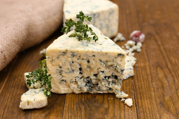 Tasty blue cheese with thyme, on wooden table