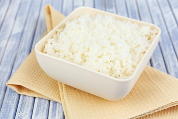 Cooked rice in bowl on wooden background