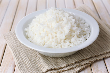 Cooked rice in bowl on wooden background