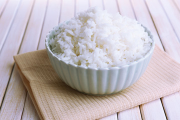 Cooked rice in bowl on wooden background