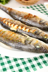Delicious grilled fish on plate on table close-up