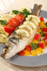 Delicious grilled fish on plate on table close-up