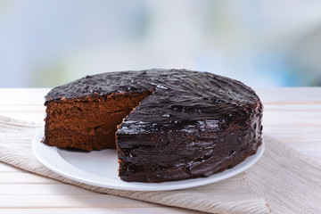 Delicious chocolate cake on plate on table on light background
