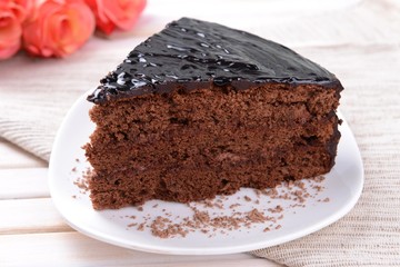 Delicious chocolate cake on plate on table close-up