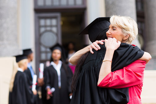 young female graduate hugging mother