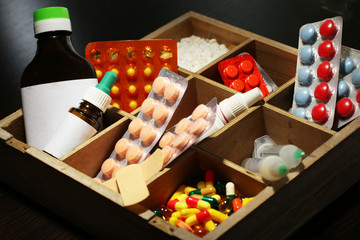Medical pills, ampules in wooden box, on color wooden