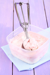 Ice cream in container and ice cream spoon