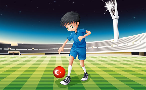 A boy kicking the ball with the flag of Turkey