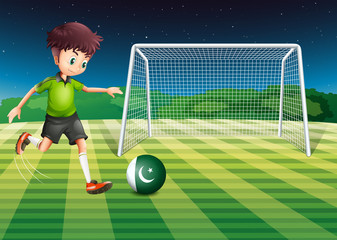 Fototapeta premium A male player kicking the ball with the flag of Pakistan