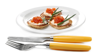 Pancakes with red caviar on plate, isolated on white