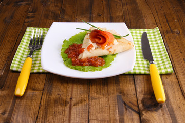 Pancake with salmon, red caviar and mayo, green onion,