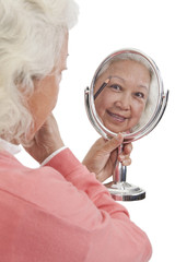 .Senior woman holding mirror.