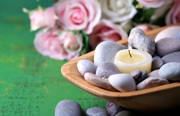 Wooden bowl with spa stones and candles