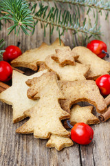 Christmas cookies on wooden table under fir branch.
