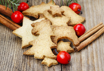 Christmas cookies on wooden table under fir branch.