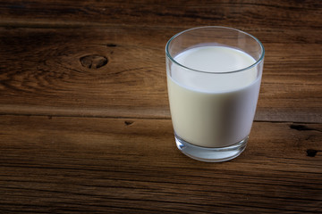glass of milk on wooden background