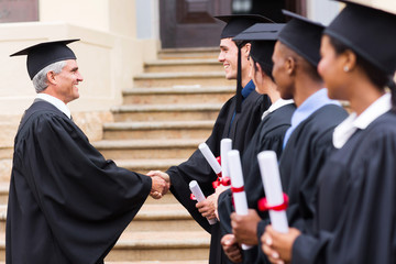 group of graduates in line handshaking with dean