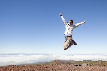 young happy woman on top of the mountain jumping of joy, Winner