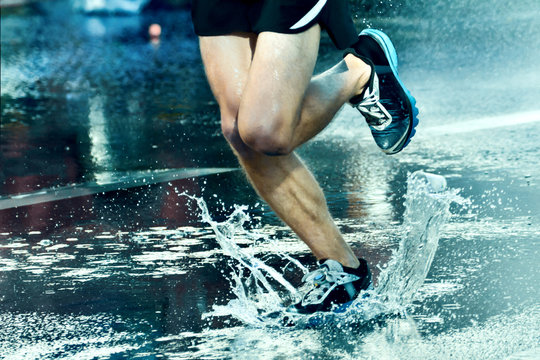 Runner running through puddle