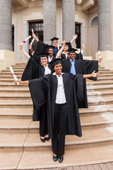 graduates standing outside college building