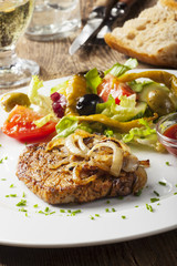 Gegrilltes Schweinesteak mit Zwiebeln