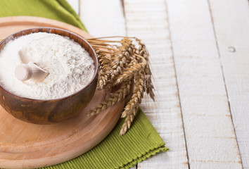 Fototapeta na wymiar Flour in wooden bowl on table