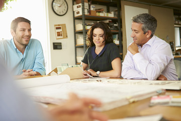 Four Architects Sitting Around Table Having Meeting