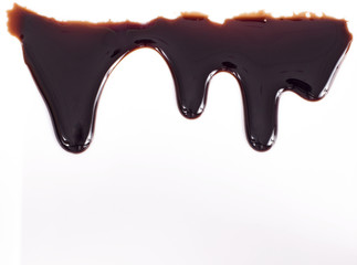Melted chocolate dripping on white background