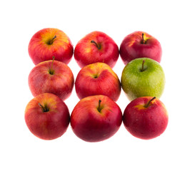 Green apple among red apples