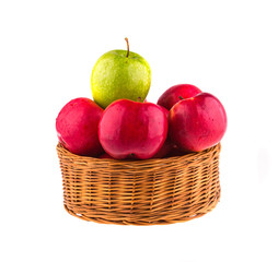 Fresh red and one green apples in a wooden basket
