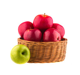 Fresh red and one green apples in a wooden basket
