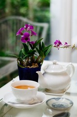 a white cup of tea with purple flower