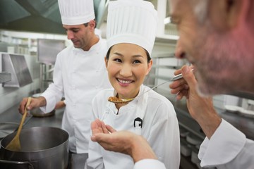 Head chef tasting a spoon of soup
