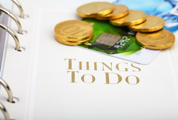 Credit card, golden coins  on the page of an organizer with the