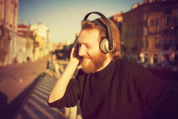 young stylish bearded man listening to music