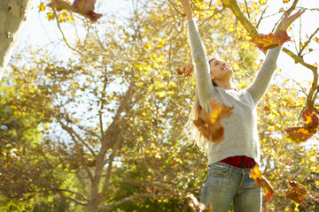 Woman Throwing Autumn Leaves In The Air