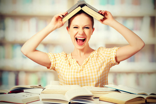 wild girl student with glasses shouts with books