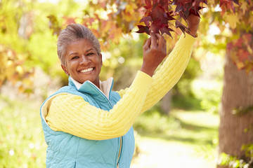 Mature Woman Relaxing In Autumn Landscape - obrazy, fototapety, plakaty