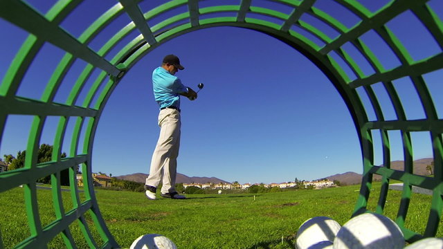 Golfer Hits Tee Shot At Driving Range