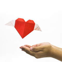 Flying love shape origami with hand at bottom