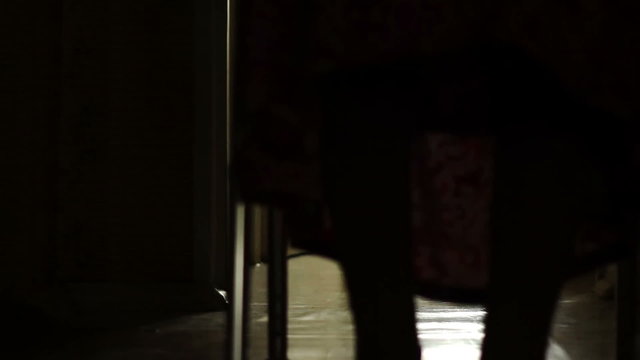 Silhouette of an very elderly woman walking at home